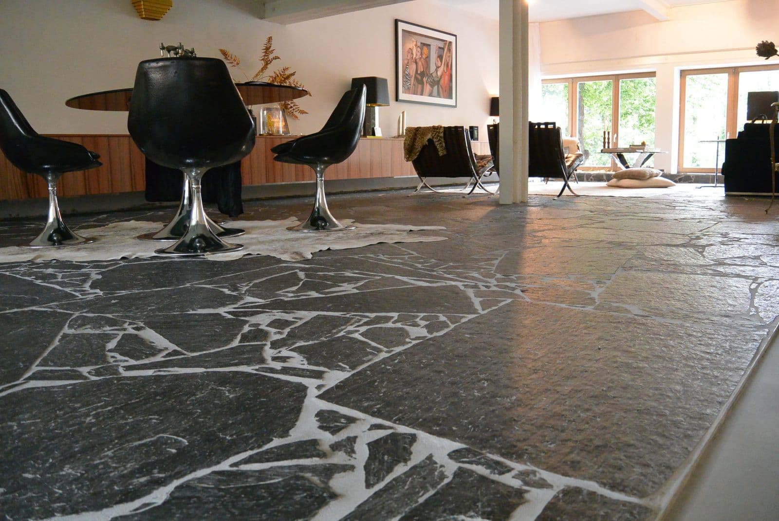 Leistenen flagstones in een woonkamer met een ronde tafel en stoelen